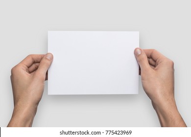 Mockup A5 Letter Horizontally Empty Blank White Holds The Man In His Hand. Isolated On A Gray Background