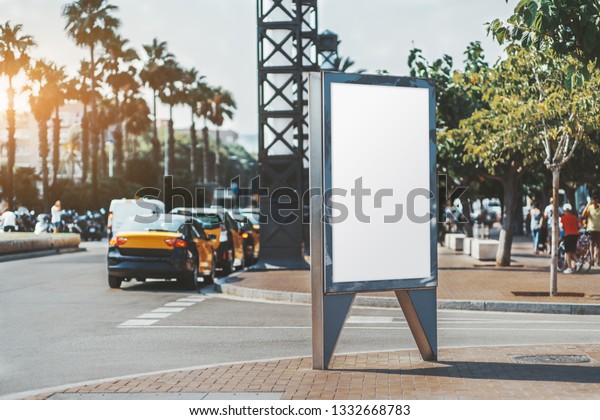 Mockup of an empty advertising poster on the\
street near the road with multiple taxi cars; vertical ad banner\
template in urban settings; a blank placeholder for information\
billboard on the\
sidewalk