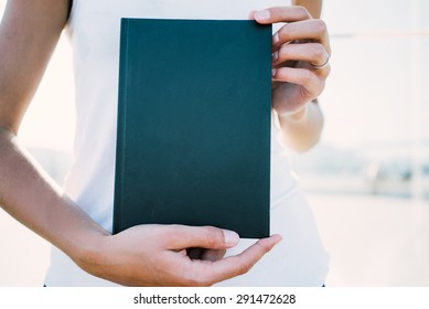 Mockup of black book holding in a hands