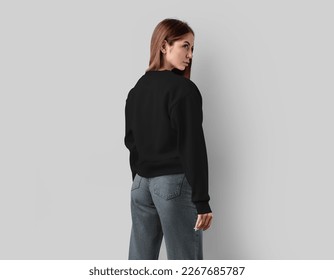 Mockup of a black cropped canvas bella shirt on a girl in jeans, fashionable textured sweatshirt, for design, print, advertising. Wear as a lifestyle template, isolated on white background, back view.