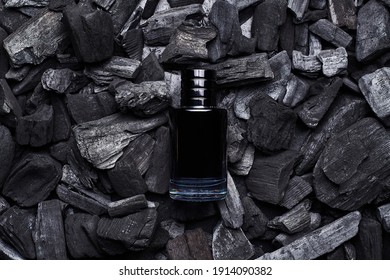 Mockup Of Black Fragrance Perfume Bottle Mockup On Dark Coals Background. Top View. Horizontal