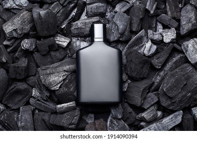 Mockup Of Black Fragrance Perfume Bottle Mockup On Dark Coals Background. Top View. Horizontal