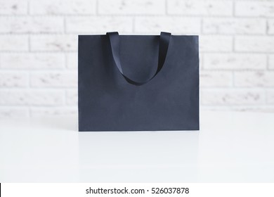 Mock-up of blank craft package, mockup of black paper shopping bag with handles on the white background