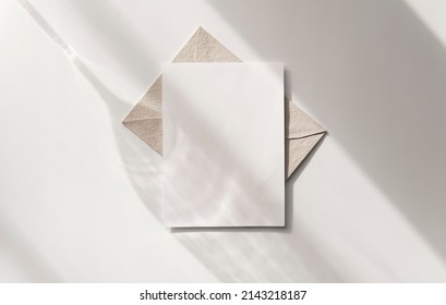 Mockup blank greeting card. Composition with shadows from a glass goblet on white background. 