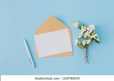 Mockup Blank Paper Card And Envelope On A Blue Background. Flat Lay, Top View