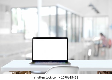 Mockup Blank Screen Laptop On Wood Table In Co-working Space.