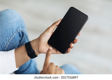 Mockup, Blank Screen Of Smartphone. Lady Hand Texting, Using Cellphone On Sofa At Home. Young African American Woman Typing On Smartphone With Empty Screen, Closeup