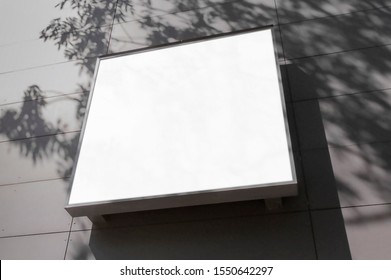 Mockup Of The Blank White Street City Outdoor Advertising Square Logo Sign On Building Wall