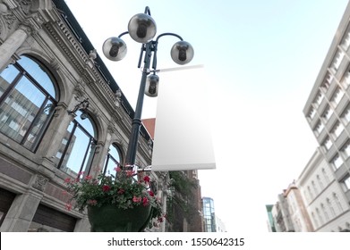 Mockup Of The Blank White Street City Outdoor Advertising Vertical Flag Hanging On Street Lamp