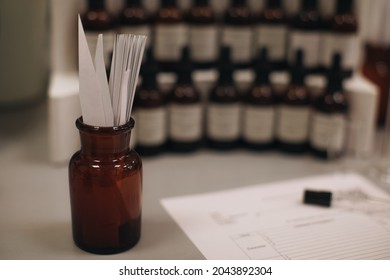 Mockup brown glass bottle with blotter paper for testing smell of essential oil and fragrance oil. Perfume tester paper strips