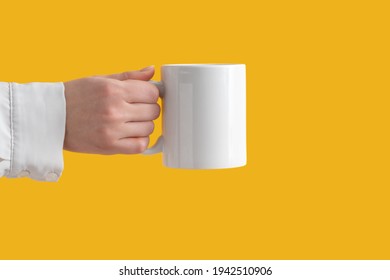 Mockup Ceramic White Coffe Cup Or Mug In Female Hands On Yellow Background With Copy Space. Blank Template For Your Design, Branding, Business. Woman In Shirt Casual Style. Real Photo.