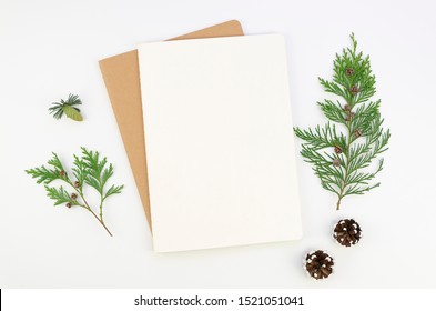 Mockup Christmas Greeting Card Letter On Craft Paper Envelope With Fur Tree Branches, Flatlay On A White Background. Mock Up With Copy Space For Lettering Text