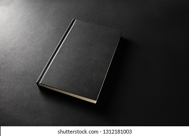 Mockup Of Closed Blank Black Book On Black Paper Background.