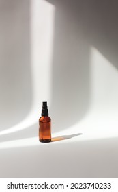 mockup of cosmetic aroma spray sanitizer in brown bottle on a grey background with shadows. minimalist beauty cosmetic concept