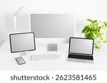 Mockup of different tech gadgets and devices on desk, laptop and desktop computers, tablet and phone