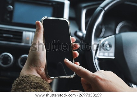 Mockup of driver hand using smartphone in car.