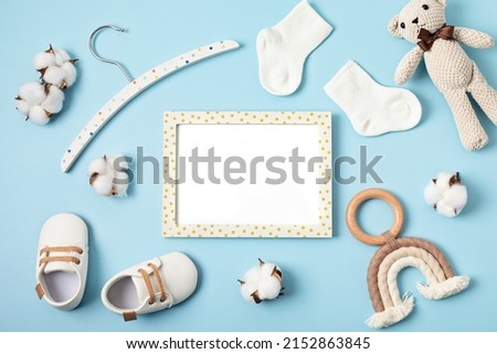 Mockup of empty frame with eco friendly baby accessories. Baby shower invitation, greeting card. Template for brand, logo, advertising. Flat lay, top view