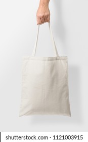 Mockup of female hand holding a blank Tote Canvas Bag on light grey background. High resolution.  - Shutterstock ID 1121003915