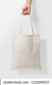 Mockup of female hand holding a blank Tote Canvas Bag on light grey background. High resolution.  - Shutterstock ID 1121003927