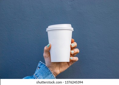 Mockup Of Female Hand Holding A Coffee Paper Cup Isolated On Dark Background