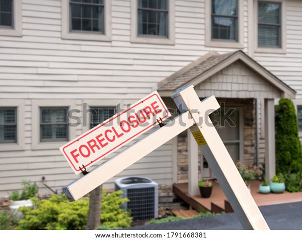 Foreclosure sign against a modern townhouse or row house