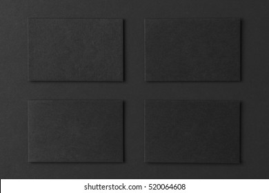 Mockup Of Four Black Business Cards Arranged In Rows At Black Paper Background.