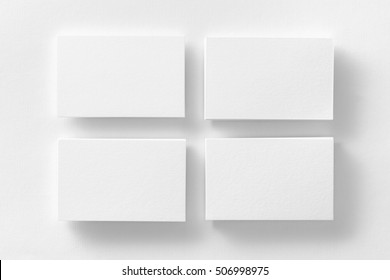 Mockup Of Four White Business Cards Stacks Arranged In Rows At White Design Paper Background.