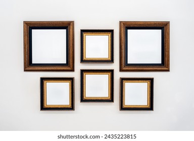 Mockup group of white blank spaces on six square painting art frames, or photography set with mounted hanging decoration on white clean wall background, showing at home, or museum or art gallery.