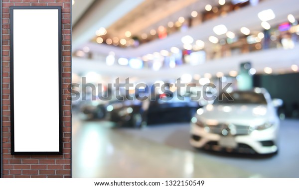 Mockup image, blank billboard, label,\
vertical sign post in luxury cars showroom with blurred car\
displayed and light bokeh for\
advertisement.