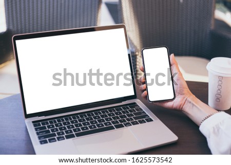 mockup image blank screen computer,cell phone with white background for advertising text,hand woman using laptop texting mobile contact business search information on desk in cafe.marketing,design