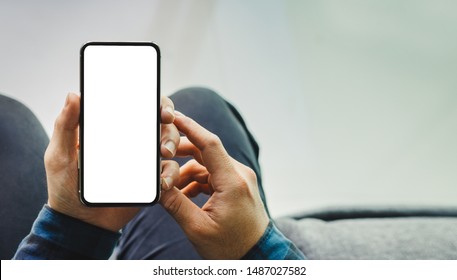 Mockup image blank white screen cell phone.men hand holding texting using mobile on desk at home office. background empty space for advertise text. contact business,people communication,technology  - Shutterstock ID 1487027582