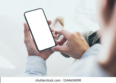 Mockup Image Blank White Screen Cell Phone.men Hand Holding Texting Using Mobile On Desk At Home Office. Background Empty Space For Advertise Text.people Contact Marketing Business And Technology 