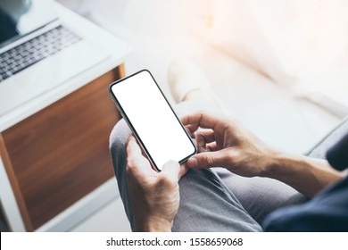 Mockup Image Blank White Screen Cell Phone.men Hand Holding Texting Using Mobile On Desk At Home Office. Background Empty Space For Advertise Text.people Contact Marketing Business And Technology 