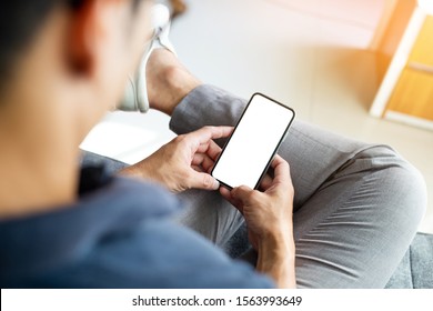 Mock-up Bild leere weißen Bildschirm Handy.Männer Hand halten Texting mit Handy entspannen auf Sofa zu Hause. Hintergrund-Leerzeichen für Werbetext.Personen kontaktieren Marketingunternehmen und -technologie 