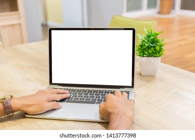Mockup image of a businessman using laptop with blank white desktop screen working in home- Image - Shutterstock ID 1413777398