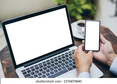 mockup image computer,cell phone white blank screen for hand typing text,using laptop contact business searching information in workplace on desk at office.design creative work space on wooden desk