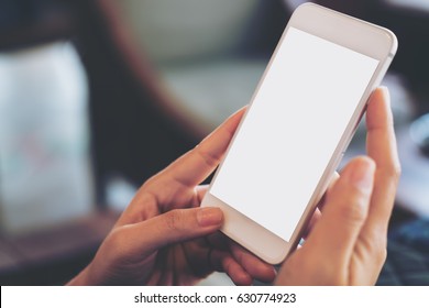 Mockup image of hand holding mobile phone with blank white screen in vintage cafe - Shutterstock ID 630774923