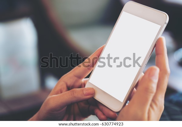 ビンテージカフェで白い空のスクリーンを持つ携帯電話を持つ手のモックアップ画像 の写真素材 今すぐ編集 ビンテージカフェで白い空のスクリーンを持つ携帯電話を持つ手のモックアップ画像 の写真素材 今すぐ編集