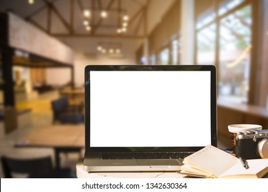 Mockup image of laptop with blank white screen with camera,notebook,coffee cup on wooden table of In the coffee shop background. - Shutterstock ID 1342630364