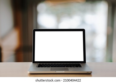 Mockup image of laptop with blank white screen on wood  table at in office with background light bokeh.- Image - Shutterstock ID 2100404422