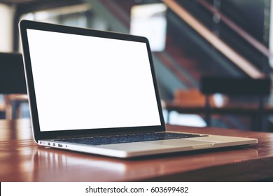 Mockup Image Of Laptop With Blank White Screen On Wooden Table In Modern Loft Cafe