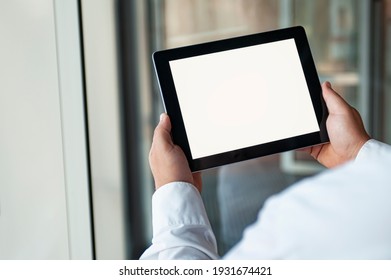 Mockup Image Of A Man Holding Black Tablet In Hand With Blank White Screen On Background In The Door