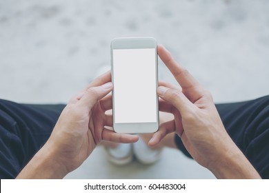 Mockup Image Of A Man Sitting On The Street And Holding White Mobile Phone With Blank White Screen 