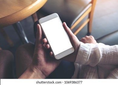 Mockup Image Of Man And Woman's Hands Holding And Looking At White Mobile Phone With Blank Desktop Screen Together 
