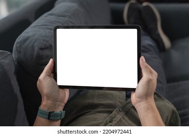 Mockup Image Of Man's Hand Holding White Tablet Pc With Blank White Screen At Home