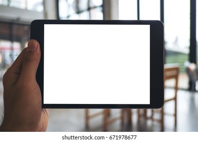 Mockup Image Of A Man's Hand Holding And Showing Black Tablet Pc With Blank White Screen In Cafe