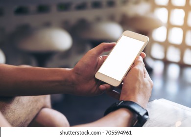 Mockup Image Of Man's Hands Holding White Mobile Phone With Blank Screen In Modern Cafe