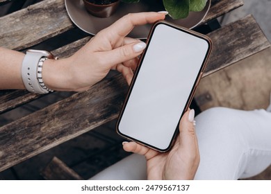 Mockup image of smartphone for advetising. Mock up image of woman hand holding and using smartphone with blank screen for mobile app design or text advertisement - Powered by Shutterstock