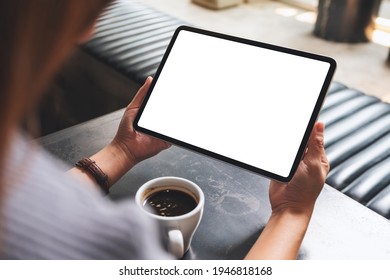 Mockup image of a woman holding digital tablet with blank white desktop screen in cafe - Powered by Shutterstock