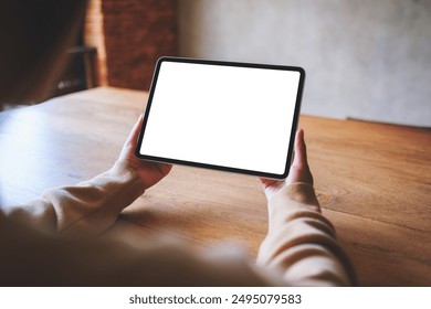 Mockup image of a woman holding digital tablet with blank white desktop screen - Powered by Shutterstock